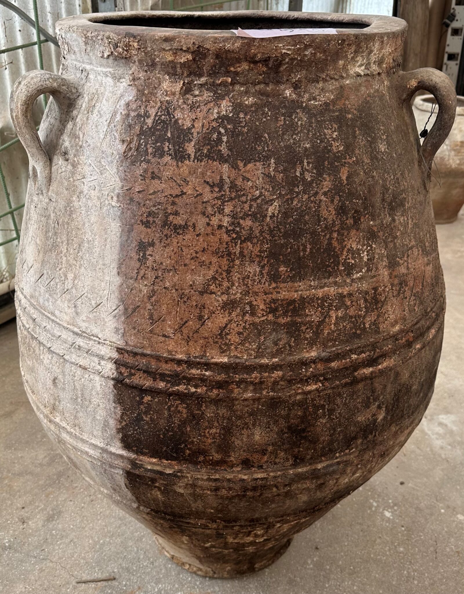 vintage Greek Pithari oil jar with a dark patina on one half and white wash on the other half