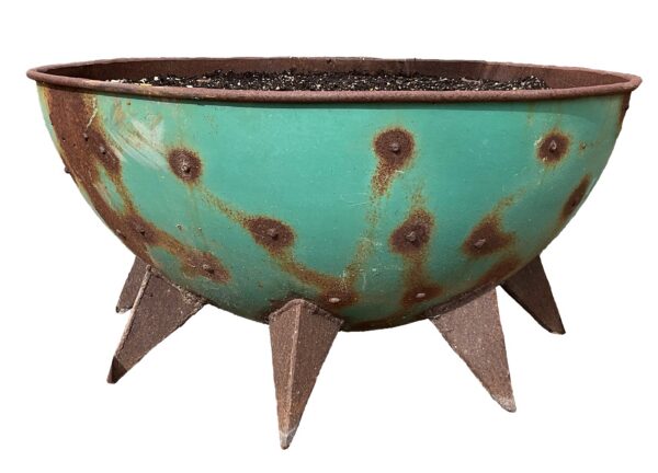 Round bowl-shaped rusted steel planter with teal-green patina, rusty spots, and angular pointed feet