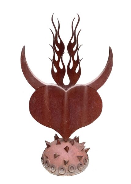 Rusted steel heart sculpture with curved horns and flame details rising from the top, mounted on a spiked spherical base