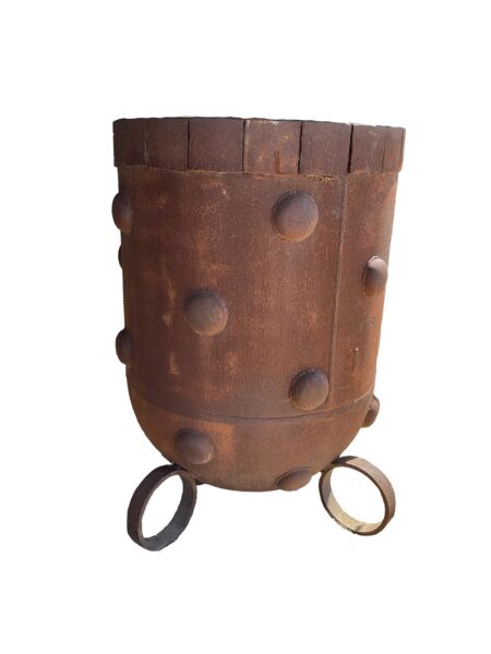 Tall up-cycled metal planter with a rounded base, rust patina, decorative raised dome studs, and ring-shaped feet