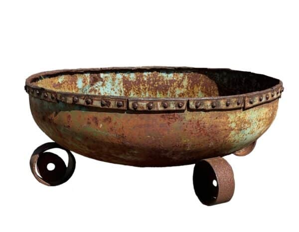 Wide round up-cycled metal bowl planter with a riveted rim, green and rust patina, and ring-shaped feet.