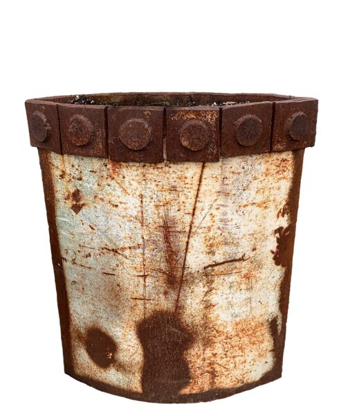 Tall cylindrical planter made of upcycled metal with weathered multicolor paint patina, raised banded rim, and four ring-shaped feet.